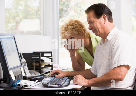 Couple in home office at computer frowning Stock Photo