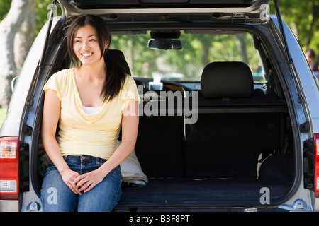 Woman sitting in back of van smiling Stock Photo
