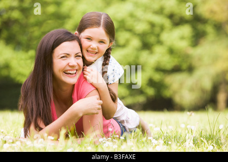 Mother and daughter lying outdoors smiling Stock Photo