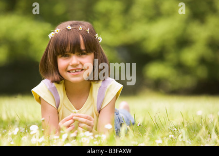 Young girl lying outdoors with flowers smiling Stock Photo