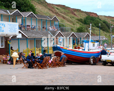 Alfresco cafe,beach chalets and a boat with wheels,on the promenade at Filey,North Yorkshire,England,uk. Stock Photo