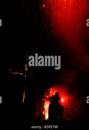 A cross and effigy of Guy Fawkes burns at the Cliffe bonfire society firework display in Lewes, sussex. 2007 Stock Photo