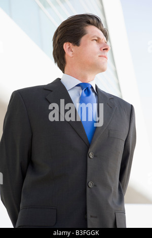 Businessman standing outdoors by building Stock Photo