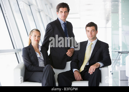 Three businesspeople sitting in office lobby Stock Photo