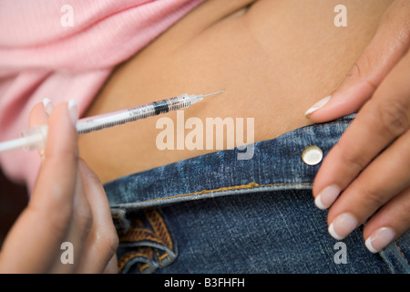 Woman injecting drugs to prepare for IVF treatment Stock Photo