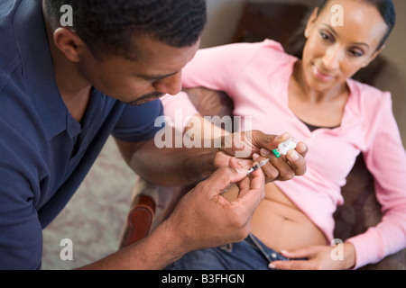 Man helping woman inject drugs to gain pregnancy (selective focus) Stock Photo