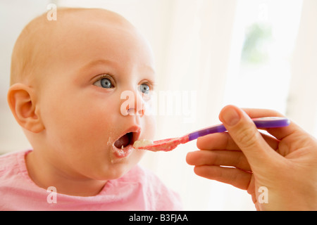 Mother feeding baby food to baby Stock Photo