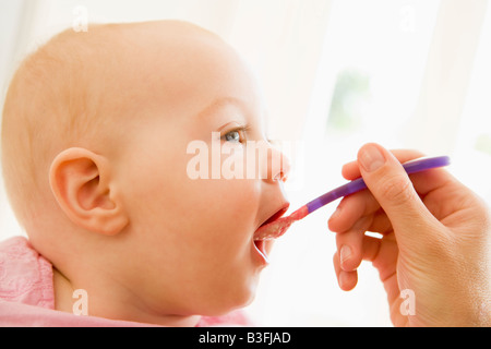 Mother feeding baby food to baby Stock Photo