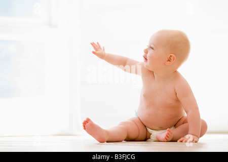 Baby sitting indoors Stock Photo