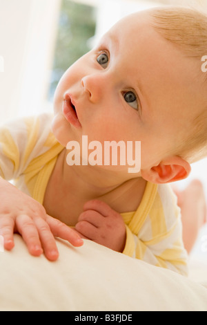 Baby lying indoors Stock Photo