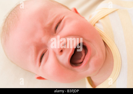 Baby lying indoors crying Stock Photo