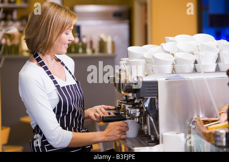 Woman making coffee in restaurant smiling Stock Photo