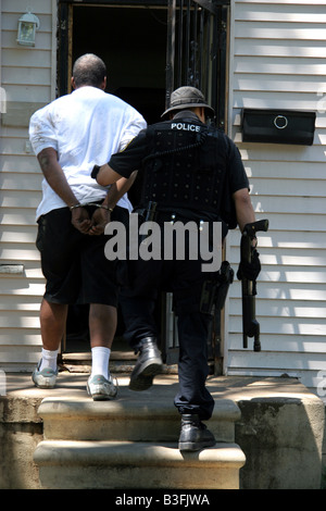 Detroit Narc cop with arrested suspect after a drugs raid on a suspected crack house Stock Photo