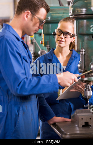 Two machinists working on machine Stock Photo