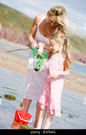 Mother and daughter at beach fishing and smiling Stock Photo