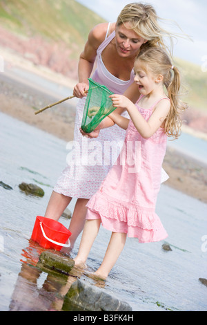 Mother and daughter at beach fishing and smiling Stock Photo