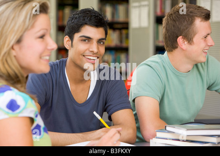 Three people in library studying (selective focus) Stock Photo