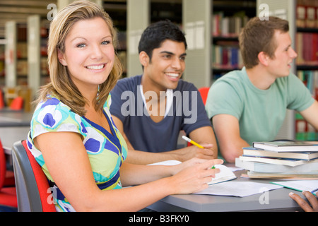 Three people in library studying (selective focus) Stock Photo