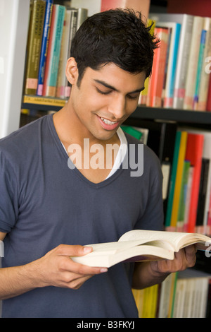 Man in library reading book Stock Photo