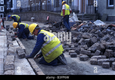 Workmen laying cobblestones Stock Photo