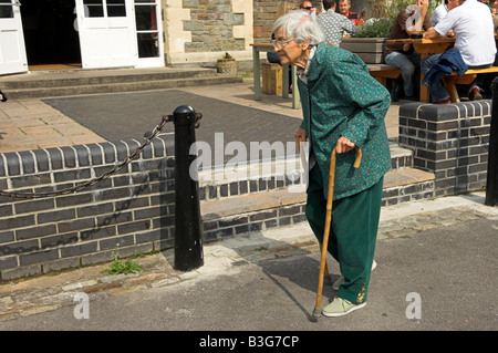 Active elderly English 92 year old woman walking with two canes Stock Photo