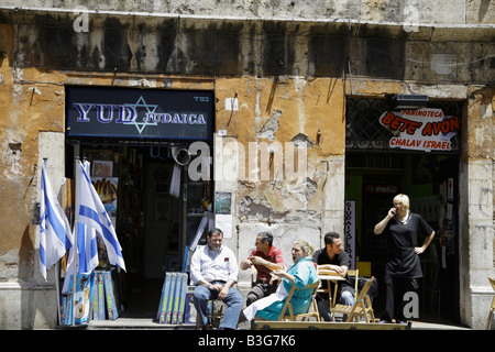 Street scene in the Rome ghetto Via del Portico d'Ottavia. People sitting outside shops in Rome Jewish quarter. Stock Photo