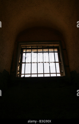 one high dark prison cell window with metal bars Stock Photo