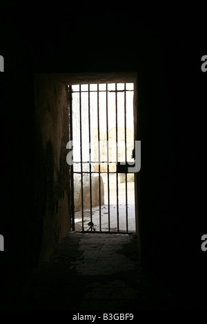 one secluded prison cell door in dark black room Stock Photo