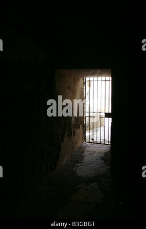 one secluded prison cell door in dark black room Stock Photo