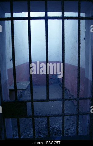 one old derelict prison cell with metal bar door Stock Photo