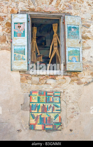 model figures of man and woman shopping in upstairs window at the book village of Montolieu in Languedoc Southern france Stock Photo