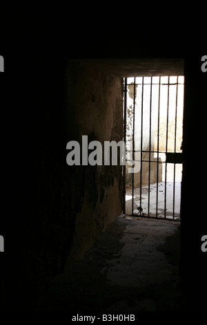 one secluded prison cell door in dark black room Stock Photo