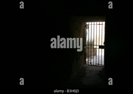 one secluded prison cell door in dark black room Stock Photo