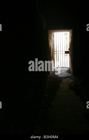 one secluded prison cell door in dark black room Stock Photo