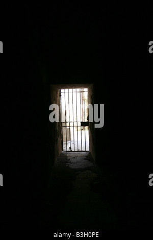 one secluded prison cell door in dark black room Stock Photo