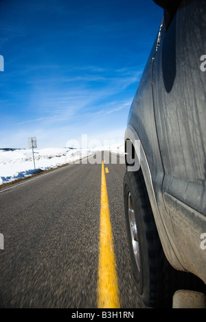 Perspective shot of SUV driving down road in snowy Colorado during winter Stock Photo