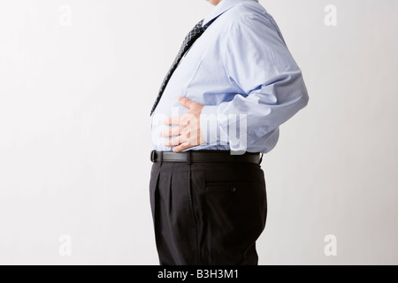 Businessman touching his belly Stock Photo