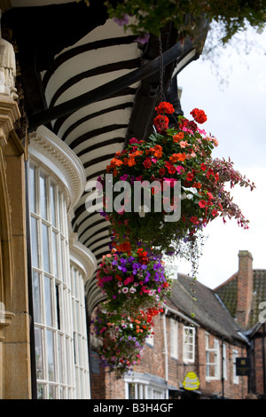 Hanging Flower Display in front of a row of shops in York Stock Photo