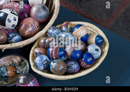Imported brightly painted Easter eggs from Africa in baskets on a market stall Stock Photo
