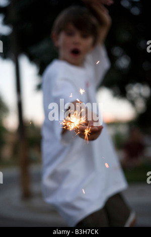 close up of child holding a sparkler burning, july fourth, celebration, eight year old boy Stock Photo