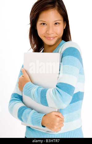 A pretty young asian girl in blue holding silver laptop Stock Photo