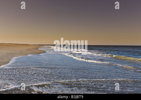 The Breakwater Lighthouse with waves crashing against the Delaware shoreline at Cape Henlopen State Park Stock Photo