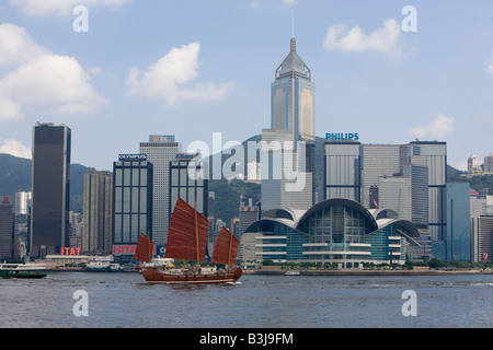 Traditional Chinese Junk sailing at the Victoria harbour with the Hong Kong skyline in background Stock Photo