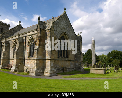 The church at Rudston East Yorkshire with an ancient monolith 7 6 metres high in the churchyard Stock Photo