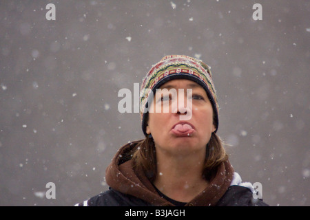 Woman catching snow on tongue Stock Photo - Alamy