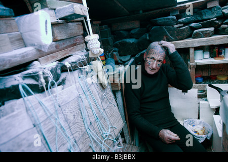 Tattooed hermit Tom Leppard (aka Leopard Man) comfortable in his secret makeshift underground hideaway shelter on Skye, Scotland Stock Photo