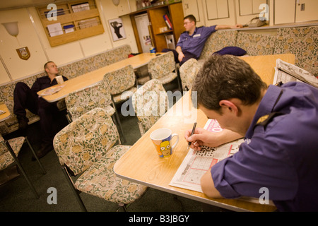 Royal Navy crew spend leisure time in the Junior Ratings wardroom aboard HMS Vigilant, a Vanguard class nuclear submarine Stock Photo