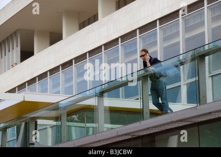 Man talking on mobile phone outside the Royal Festival Hall South Bank London England Stock Photo