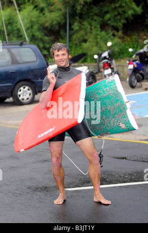 A smiling surfer who just broke his surfing board in the rough surf in South-West France. Stock Photo