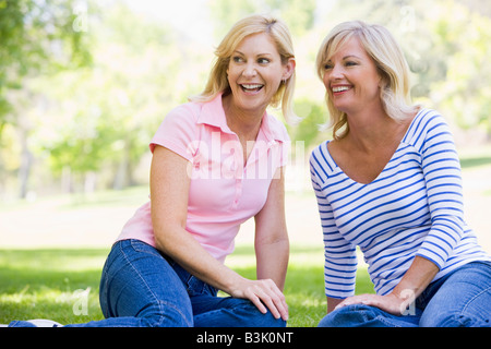 Two women sitting outdoors smiling Stock Photo